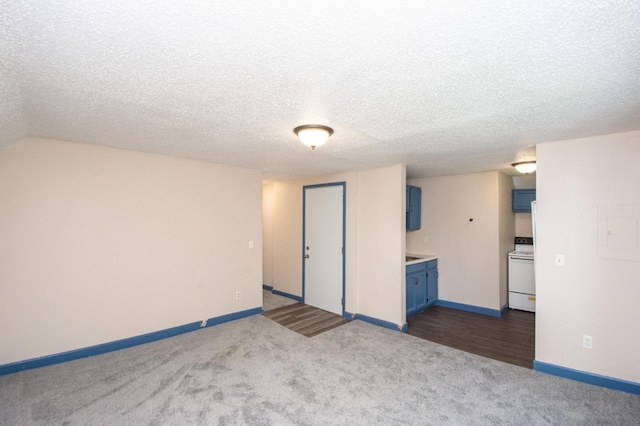 interior space with baseboards, dark carpet, and a textured ceiling