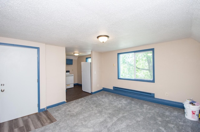 interior space featuring a baseboard heating unit, baseboards, carpet, lofted ceiling, and a textured ceiling