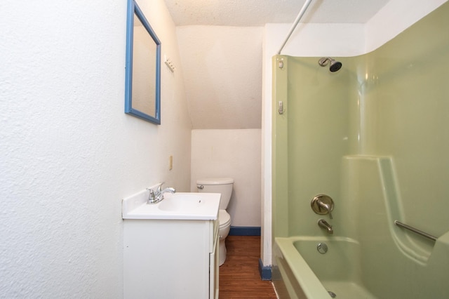 full bathroom with vanity, wood finished floors, lofted ceiling,  shower combination, and toilet