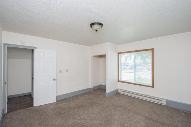 unfurnished bedroom with a baseboard heating unit, a textured ceiling, a closet, and carpet flooring