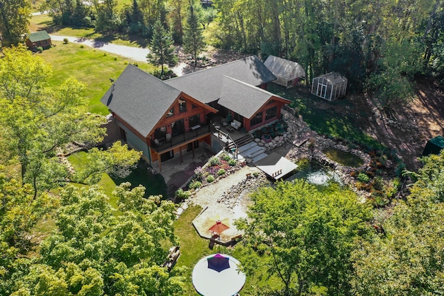 birds eye view of property featuring a forest view