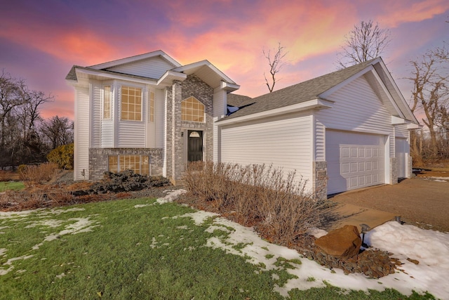 traditional home with a garage, stone siding, brick siding, and a front yard