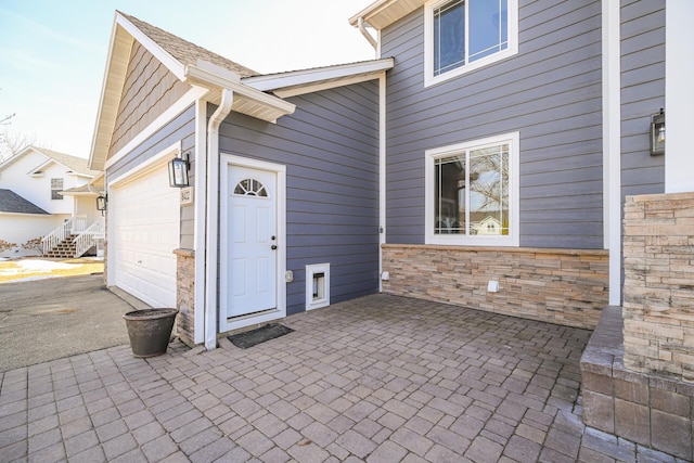 view of patio featuring an attached garage and driveway