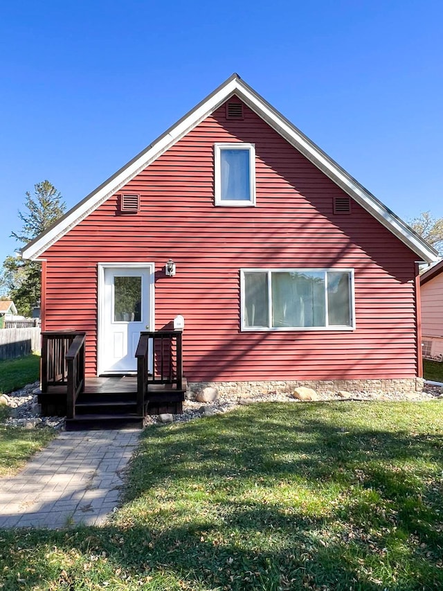 rear view of house featuring a lawn and a wooden deck