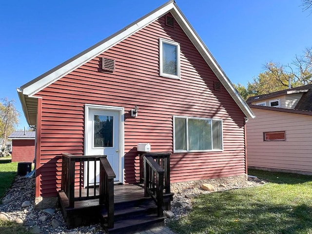 rear view of house featuring metal roof, a lawn, and a deck