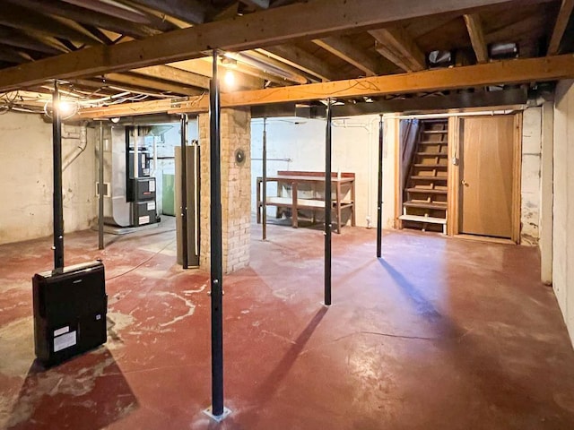 unfinished basement with heating unit and stairs