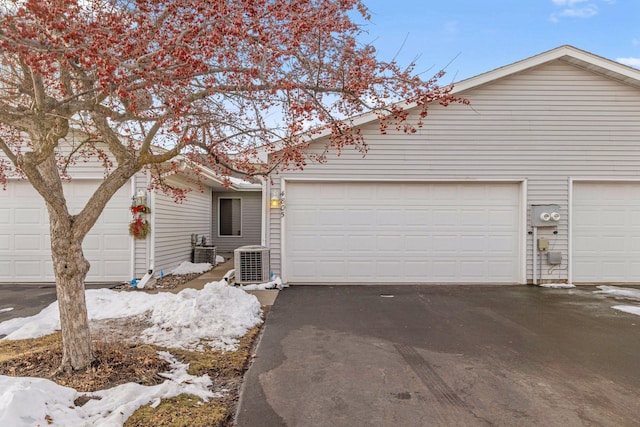 view of front of property featuring cooling unit and a garage