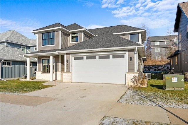 view of front of property featuring a front yard, roof with shingles, an attached garage, concrete driveway, and brick siding