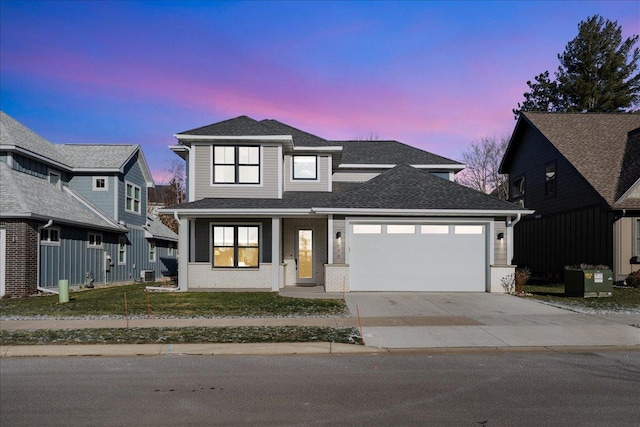 view of front of property with driveway, roof with shingles, an attached garage, a lawn, and brick siding