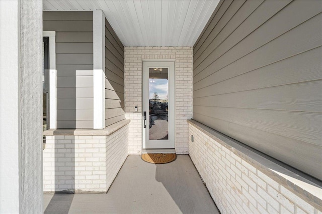 view of exterior entry featuring brick siding