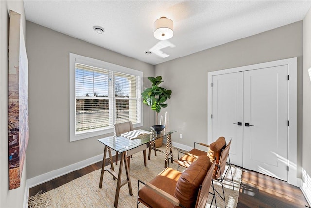 office area featuring baseboards, a textured ceiling, and wood finished floors