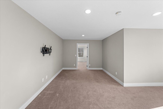 unfurnished room featuring recessed lighting, light colored carpet, and baseboards