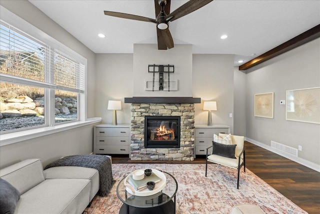 696 Inspiration Pl, Bayport, MN 55003 - living area featuring beamed ceiling, a fireplace, a ceiling fan, visible vents, and dark wood-style floors