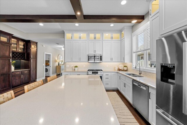 696 Inspiration Pl, Bayport, MN 55003 - kitchen featuring a sink, washer / dryer, backsplash, appliances with stainless steel finishes, and beam ceiling