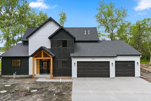 modern farmhouse style home featuring board and batten siding, a garage, driveway, and a shingled roof