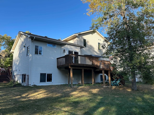 back of property with a lawn, a deck, and fence