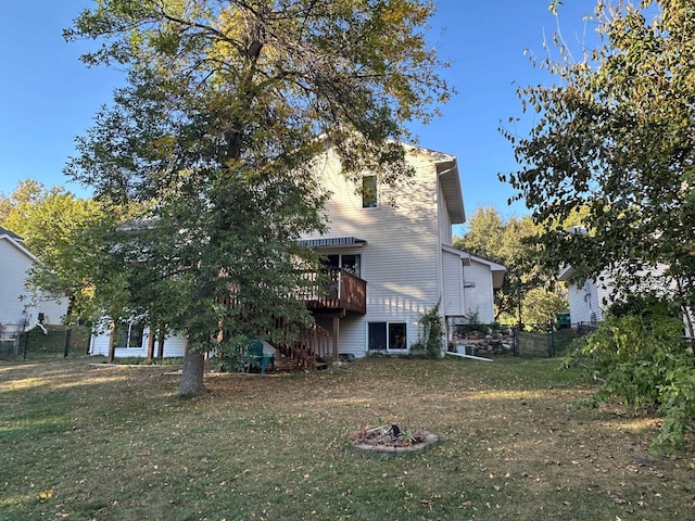 back of property with a lawn, a deck, stairs, and fence