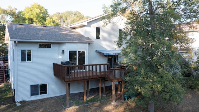 rear view of house featuring a wooden deck and a shingled roof