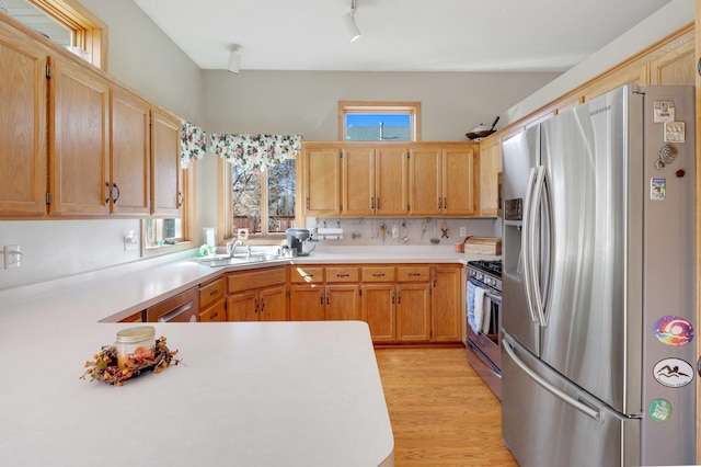 kitchen featuring light countertops, a healthy amount of sunlight, appliances with stainless steel finishes, and a sink