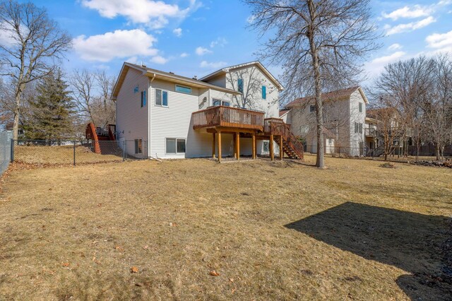 rear view of house with a yard, stairway, a wooden deck, and a fenced backyard