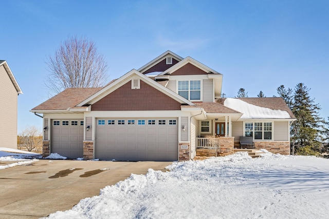 craftsman inspired home featuring a garage, stone siding, and driveway