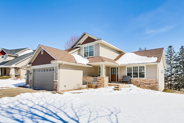 craftsman inspired home with a porch, a garage, and stone siding