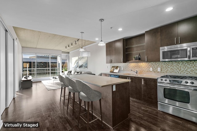 kitchen featuring decorative backsplash, dark brown cabinets, appliances with stainless steel finishes, and a center island