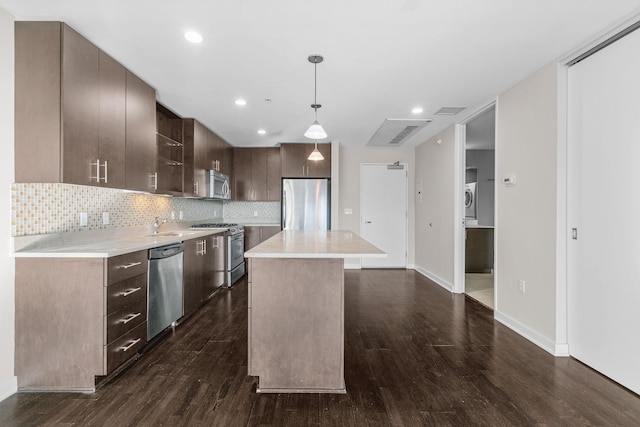 kitchen featuring light countertops, dark brown cabinets, a kitchen island, and stainless steel appliances