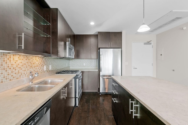 kitchen featuring a sink, backsplash, dark wood finished floors, stainless steel appliances, and dark brown cabinetry