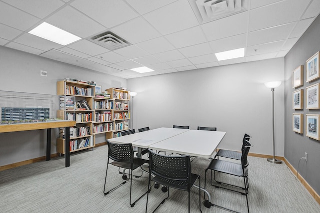 dining area with baseboards, visible vents, a drop ceiling, and light carpet