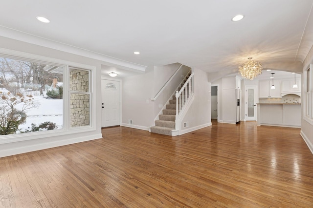 unfurnished living room featuring light wood-type flooring, stairway, and recessed lighting