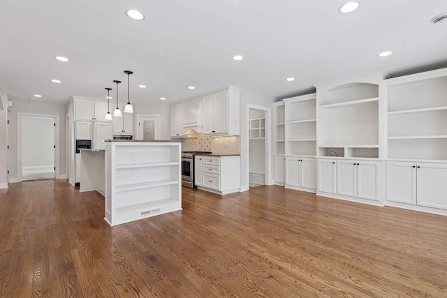 kitchen with white cabinetry, open shelves, stainless steel range with gas cooktop, and a kitchen island