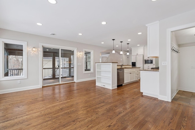 kitchen with pendant lighting, wood finished floors, white cabinetry, recessed lighting, and appliances with stainless steel finishes