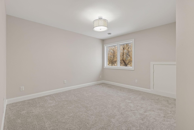 spare room with baseboards and carpet