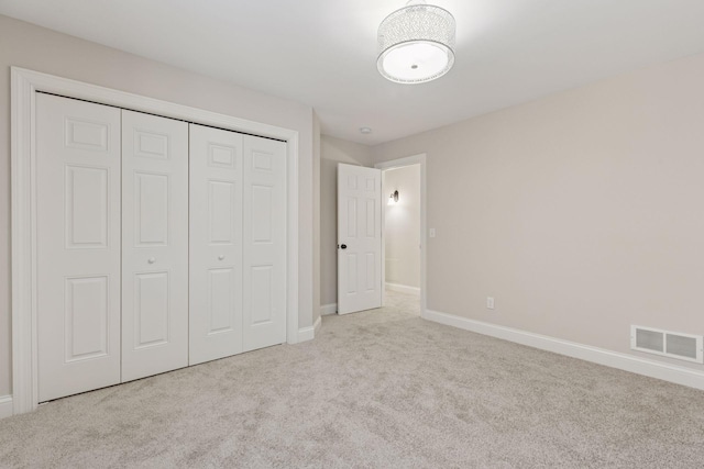 unfurnished bedroom featuring a closet, visible vents, carpet flooring, and baseboards