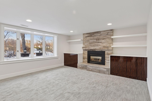 unfurnished living room with visible vents, baseboards, recessed lighting, a fireplace, and carpet flooring