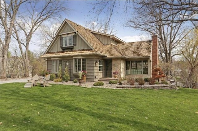 view of front of property with board and batten siding, a chimney, and a front lawn