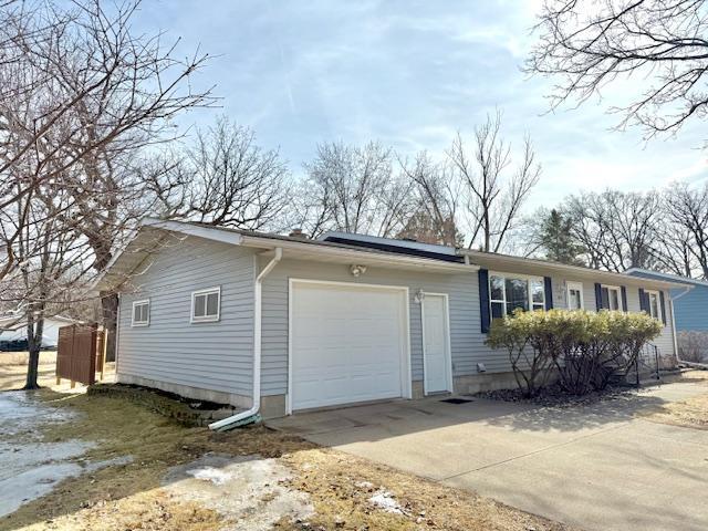 view of property exterior with driveway and an attached garage