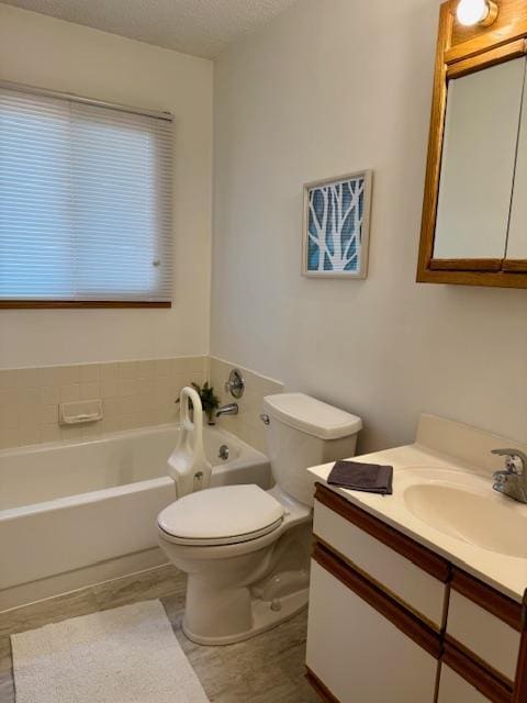 full bathroom with a garden tub, toilet, vanity, and a textured ceiling