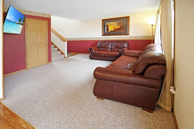 living area featuring stairs, baseboards, and carpet floors