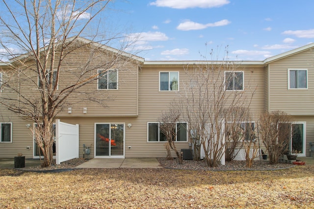 rear view of property with central AC unit and a patio area