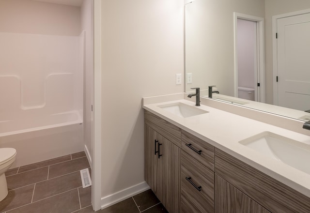 full bathroom with tile patterned floors, toilet, and a sink