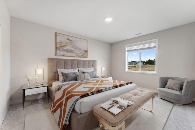 bedroom featuring baseboards, visible vents, and light carpet