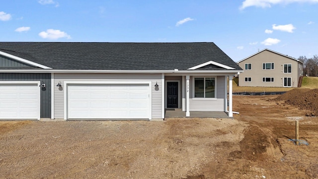 view of front of home featuring driveway, roof with shingles, covered porch, and a garage