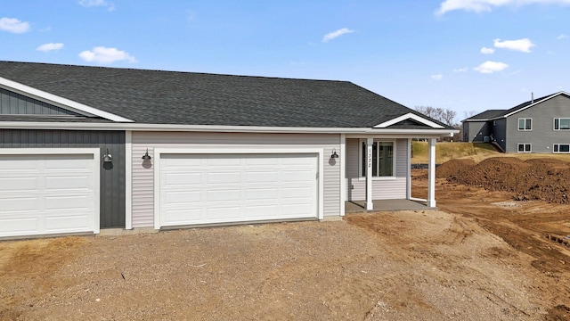 view of front of home featuring a garage, driveway, and roof with shingles