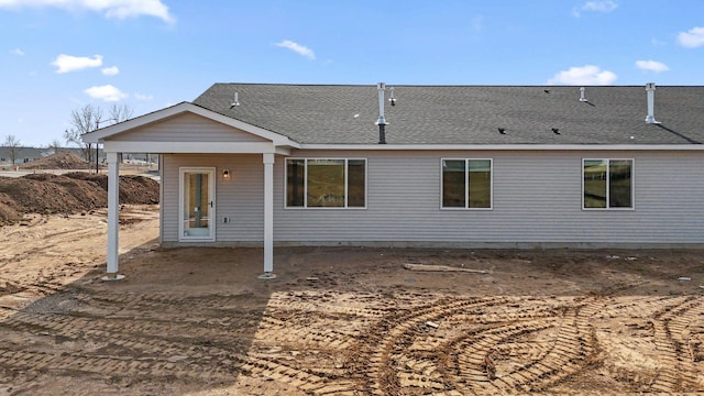 view of front of property featuring a patio and a shingled roof