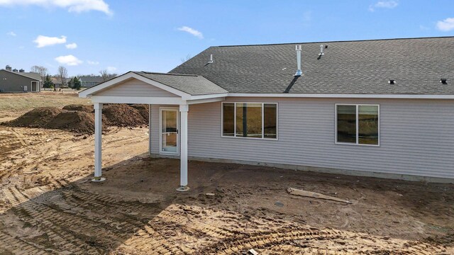 back of property featuring a patio and a shingled roof
