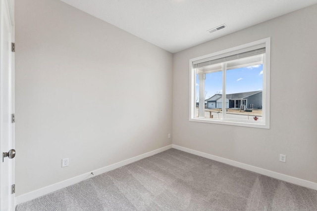 unfurnished room with visible vents, carpet flooring, and baseboards