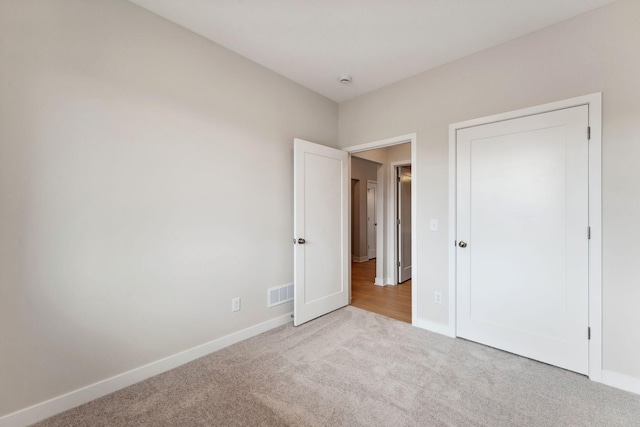 unfurnished bedroom featuring visible vents, baseboards, and carpet floors
