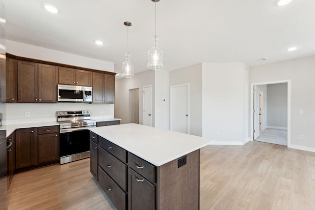 kitchen with stainless steel appliances, light countertops, light wood-style flooring, and a kitchen island